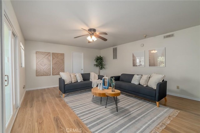 living room featuring ceiling fan and light hardwood / wood-style floors