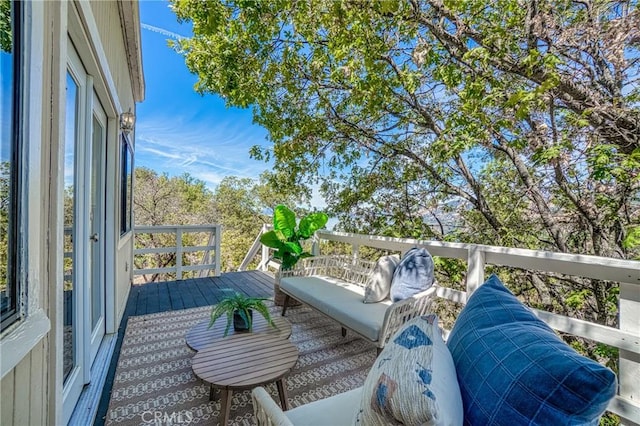 wooden balcony with an outdoor hangout area and a wooden deck