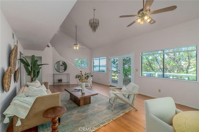 living room featuring light hardwood / wood-style floors, french doors, lofted ceiling, and ceiling fan