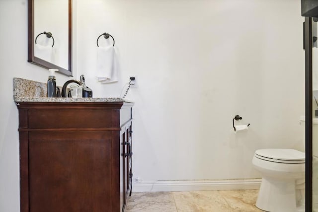 bathroom with toilet, vanity, and tile patterned flooring