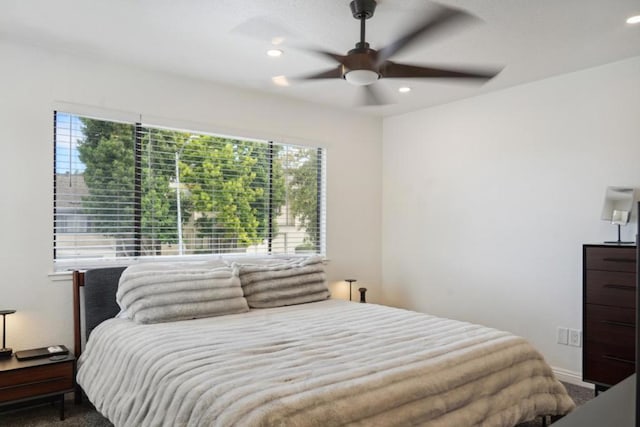 carpeted bedroom with ceiling fan and multiple windows