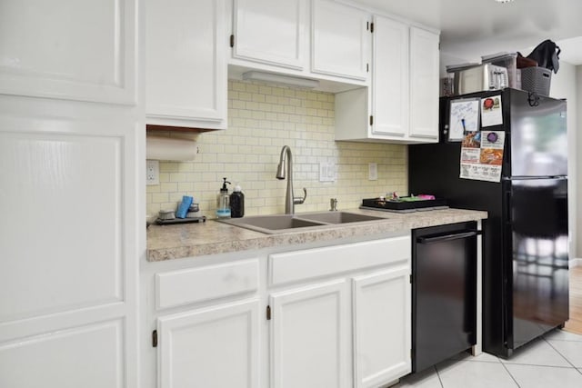 kitchen featuring light tile patterned floors, black appliances, white cabinets, and sink