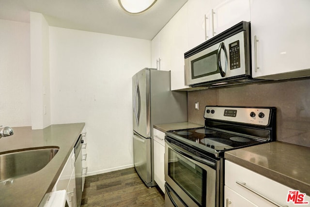 kitchen featuring appliances with stainless steel finishes, white cabinetry, dark wood-type flooring, and sink