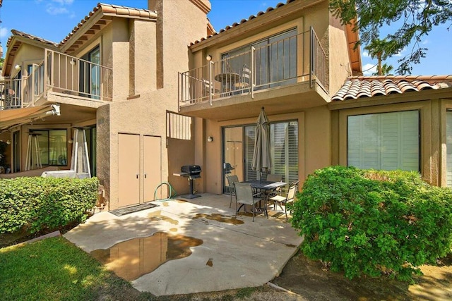 back of property with a balcony and a patio area