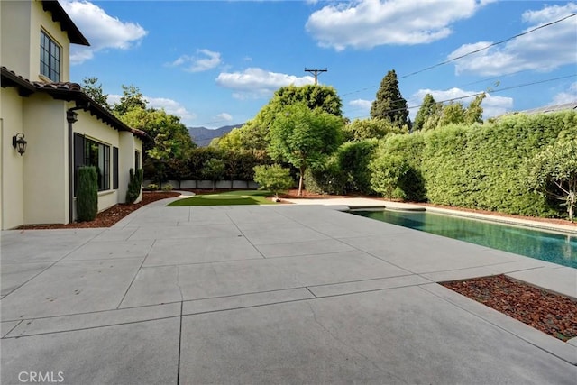 view of swimming pool with a mountain view and a patio area