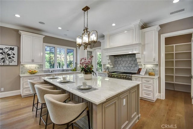 kitchen with a kitchen island, white cabinetry, backsplash, and light hardwood / wood-style flooring