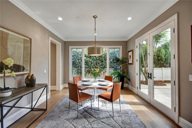 dining area with french doors, light hardwood / wood-style flooring, and crown molding