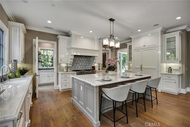 kitchen featuring white cabinets, a center island, sink, and hardwood / wood-style floors