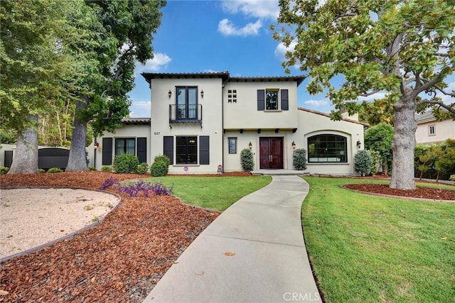 mediterranean / spanish-style house featuring a balcony and a front yard