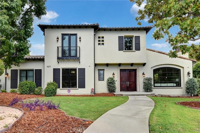 mediterranean / spanish home featuring a balcony and a front yard