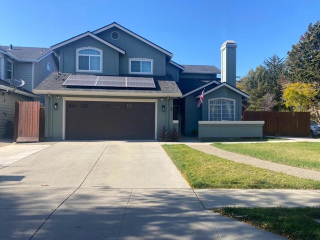 view of front property featuring a front lawn, a garage, and solar panels