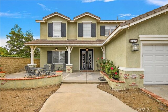 doorway to property with a garage and covered porch