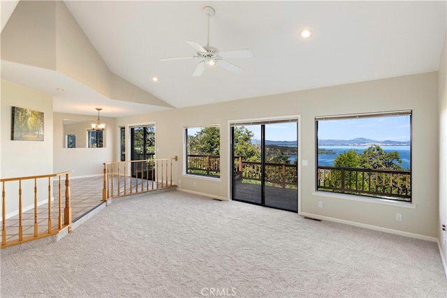 spare room with light carpet, a mountain view, ceiling fan with notable chandelier, and high vaulted ceiling