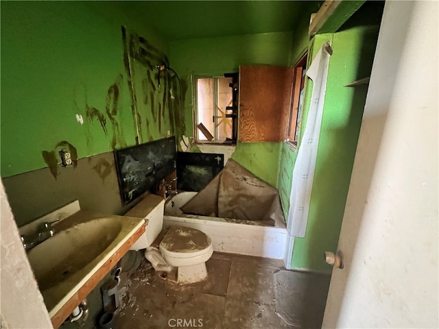 bathroom featuring a tub to relax in, sink, and toilet