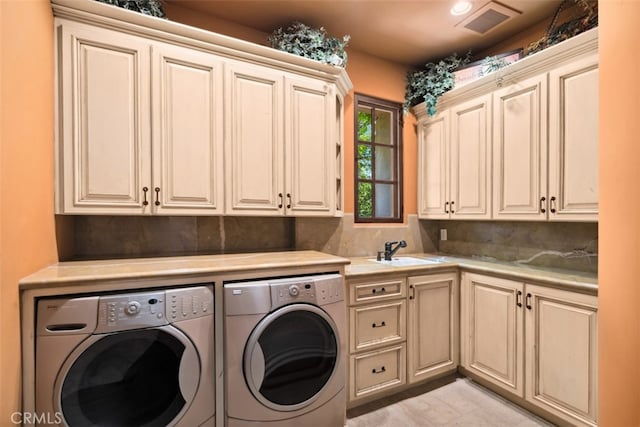 laundry room featuring cabinets, sink, and washing machine and dryer