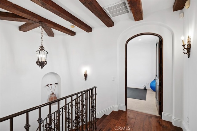 hall with beam ceiling and dark hardwood / wood-style flooring