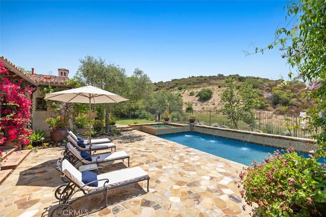 view of swimming pool with pool water feature, an in ground hot tub, and a patio area