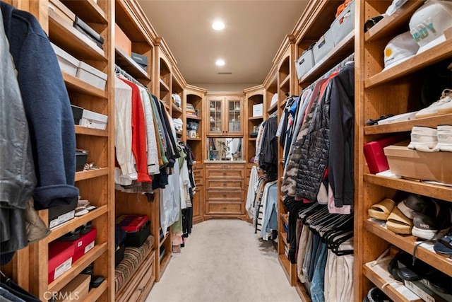 walk in closet featuring light carpet