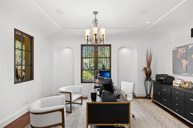 office space with an inviting chandelier and hardwood / wood-style flooring