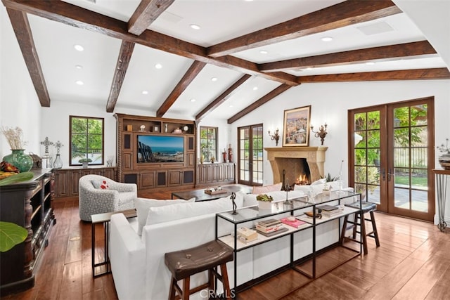 living room featuring vaulted ceiling with beams, a healthy amount of sunlight, wood-type flooring, and french doors