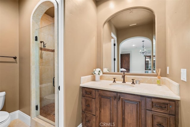 bathroom with vanity, tile patterned floors, a notable chandelier, toilet, and a shower with door