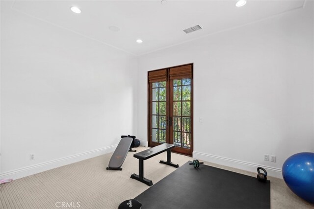 workout area with light carpet and french doors