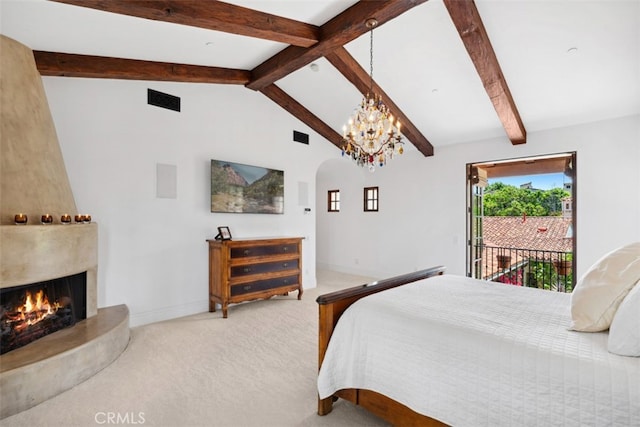 carpeted bedroom featuring lofted ceiling with beams, an inviting chandelier, a fireplace, and access to outside