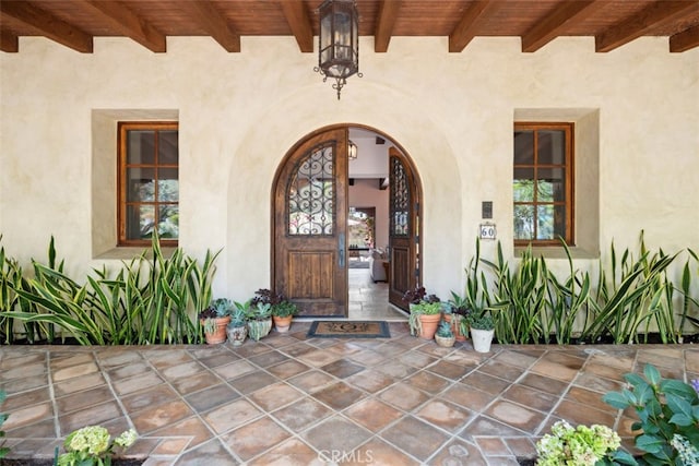 view of exterior entry with a patio area