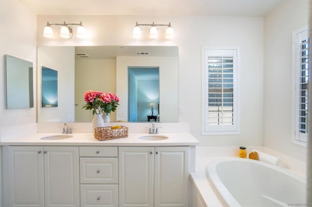 bathroom featuring vanity and tiled bath