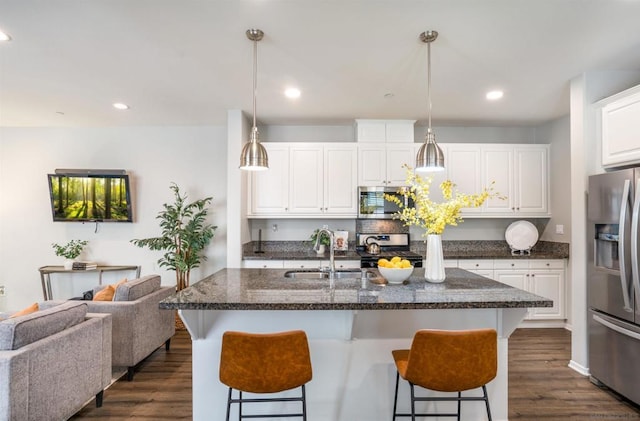 kitchen with a center island with sink, white cabinetry, sink, and appliances with stainless steel finishes