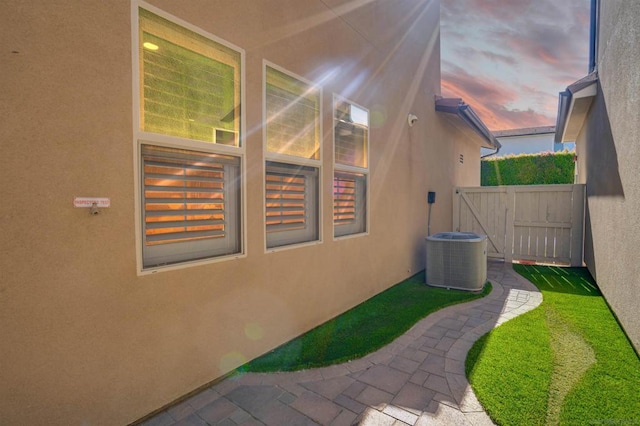 property exterior at dusk featuring cooling unit