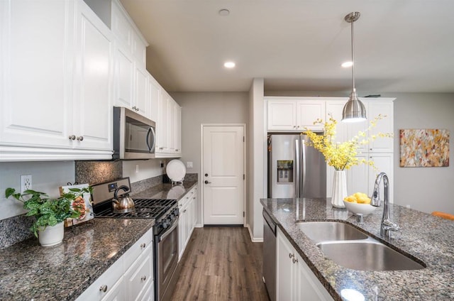 kitchen with white cabinetry, hanging light fixtures, appliances with stainless steel finishes, and dark wood-type flooring