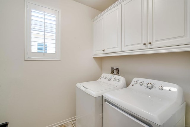 laundry room featuring washer and clothes dryer and cabinets