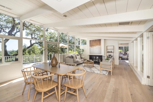 sunroom / solarium featuring lofted ceiling with beams