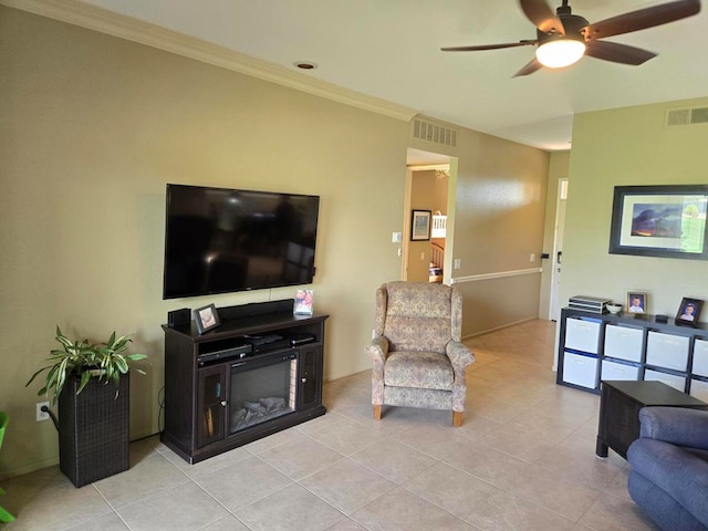 living room with ornamental molding, ceiling fan, and light tile patterned flooring