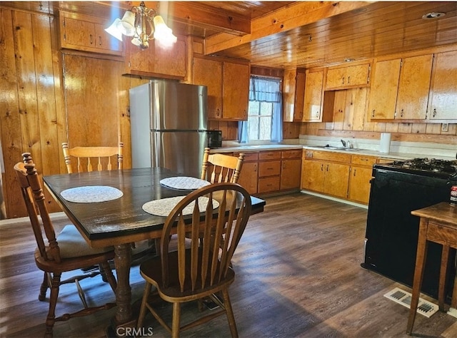 dining room featuring beamed ceiling, wood ceiling, dark hardwood / wood-style floors, and wood walls