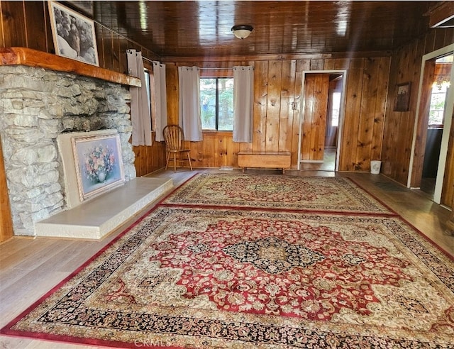 interior space with a healthy amount of sunlight, wood walls, and hardwood / wood-style floors