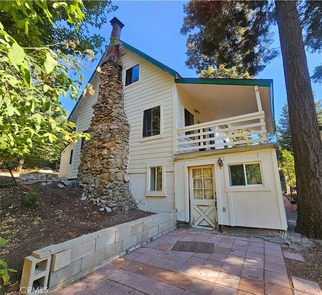 back of house featuring a patio and a balcony