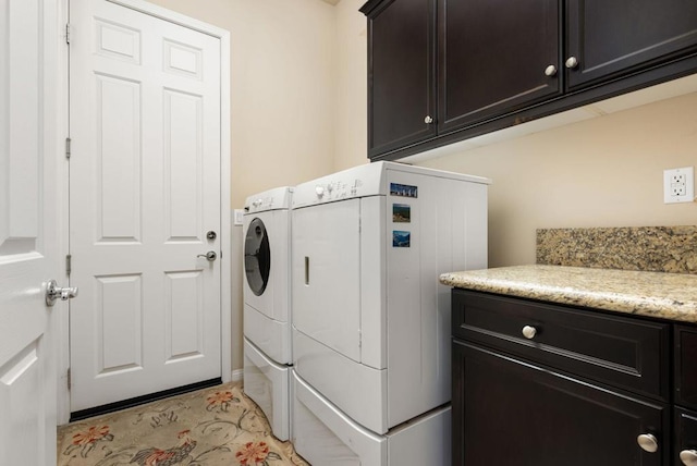 laundry area featuring washing machine and dryer and cabinets