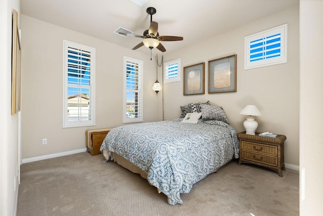 bedroom featuring multiple windows, ceiling fan, and light colored carpet