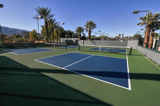 view of tennis court with basketball court and a mountain view