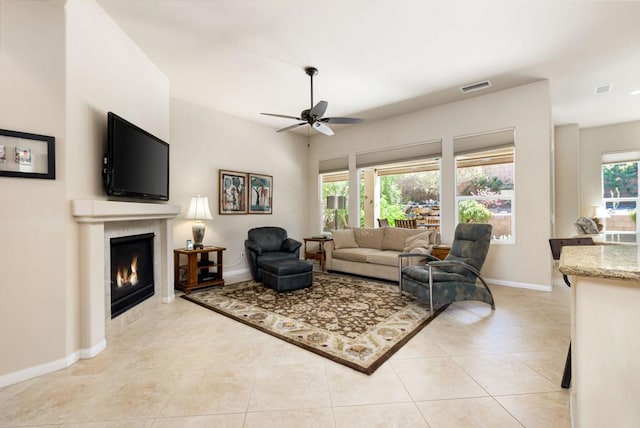 living room with light tile patterned flooring, ceiling fan, and plenty of natural light