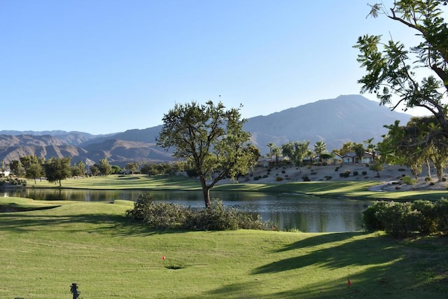 surrounding community with a water and mountain view and a lawn