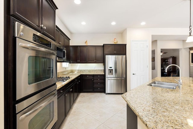 kitchen featuring stainless steel appliances, sink, ceiling fan, dark brown cabinetry, and pendant lighting