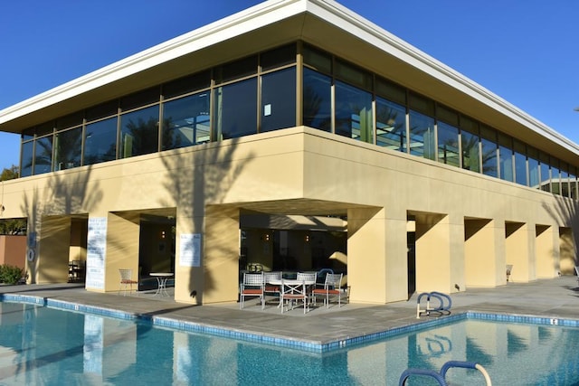 rear view of property with a patio and a community pool