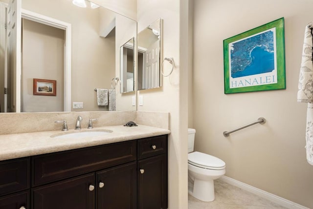 bathroom with tile patterned flooring, vanity, and toilet