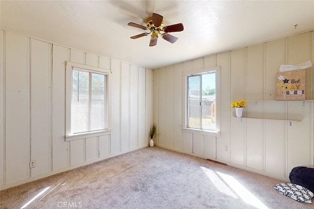 carpeted spare room featuring ceiling fan