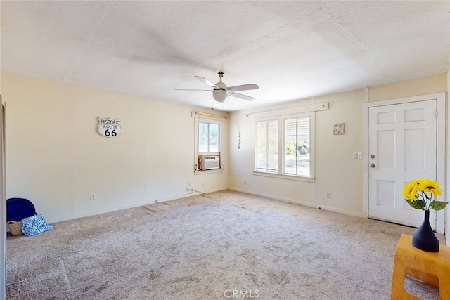 interior space featuring a textured ceiling, cooling unit, light carpet, and ceiling fan