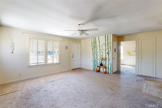 spare room featuring a textured ceiling, ceiling fan, and light colored carpet