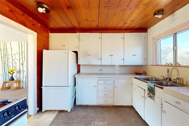 kitchen with decorative backsplash, white cabinets, white appliances, wooden walls, and sink